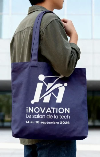 Tote bag bleu marine iNOVATION porté à l'épaule dans un contexte urbain, logo salon de la tech et dates 14-18 septembre 2026